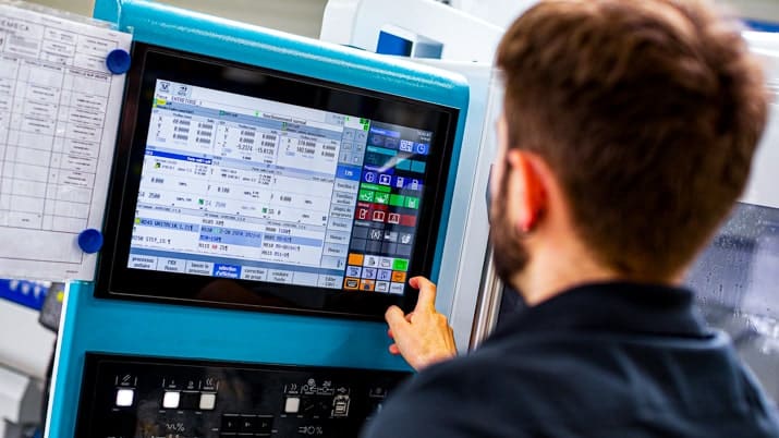 Opérateur sur une machine en train d'analyser les performances d'usinage